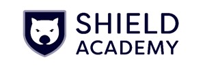 Logo for Shield Academy. Has a navy blue sheild with a light grey border and the head of a wombat in white.