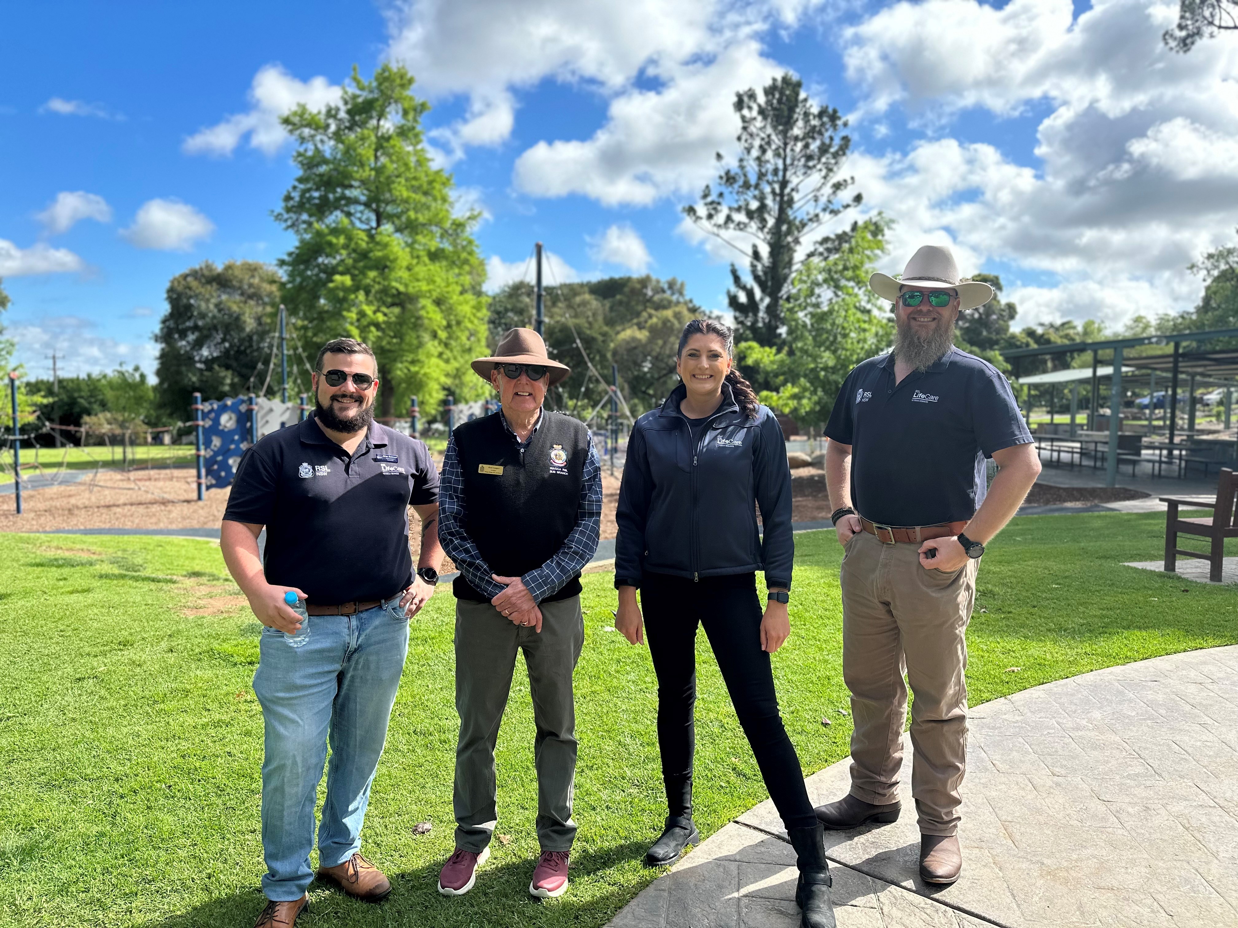 Four RSL Lifecare staff members pose, smiling, in a line in a playground