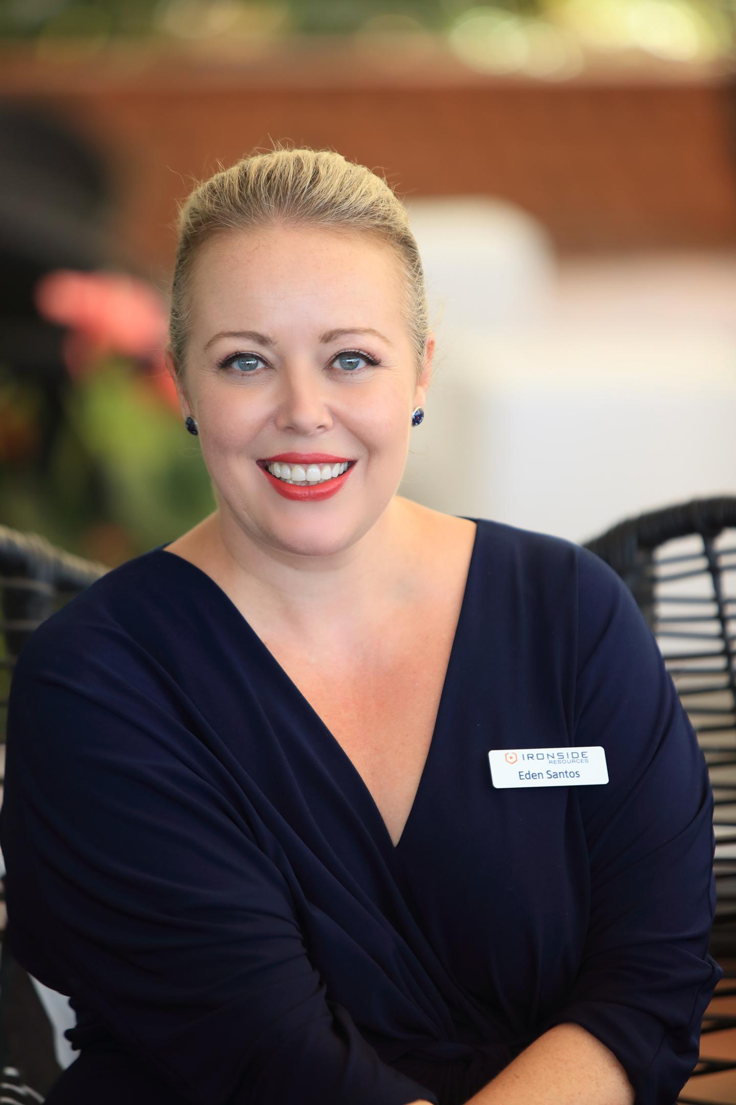 A smiling blonde woman in a dark top