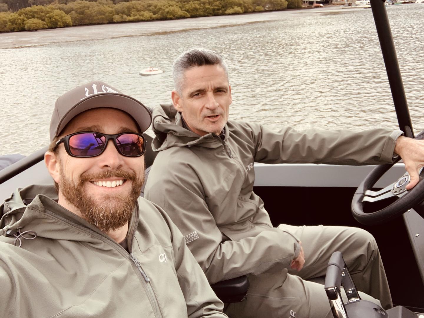 Two men in grey tracksuits on a boat